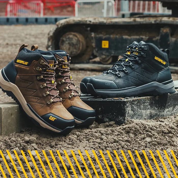 A pair of Caterpillar Inductor Mid Boot S7S in brown and black on a building site.
