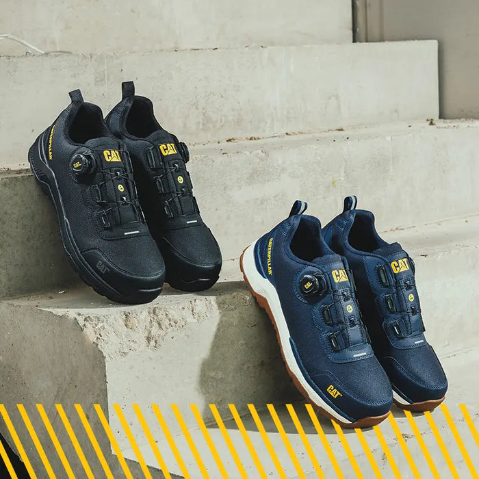 A pair of Caterpillar Inductor Tech Low Safety Trainers in black and navy propped up on concrete steps.
