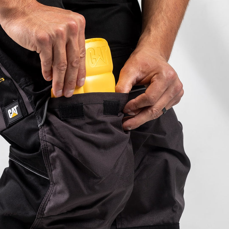 Close-up image of a man inserting a  Yellow Caterpillar Knee Pad into his work trousers