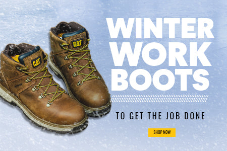 A pair of brown Caterpillar Exposition Safety Boots on an icy surface with snow falling