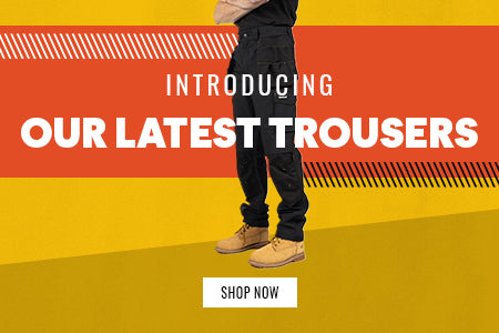 A male model wearing a pair of Caterpillar workwear trouser images on a yellow and orange background. Text reads 'INTRODUCING OUR LATEST TROUSERS. SHOP NOW'