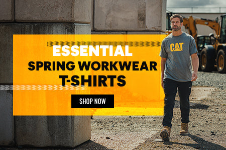 Man walking along a construction site in the sunshine, wearing a grey Caterpillar t-shirt. Text reads: 'ESSENTIAL SPRING WORKWEAR T-SHIRTS. SHOP NOW'